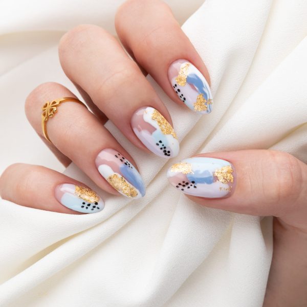 Woman's hand with fashionable nails holding fabric. Spring summer nail design. Manicure, pedicure beauty salon concept.